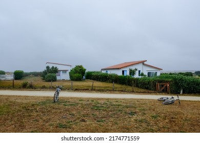 View Of Road With Two Bikes In Front And French Village Houses At The Background 