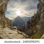 View of the rocky cliffs and mountainous landscape of Monterrey at sunrise, with the sun casting a golden glow over the rugged terrain. The distant peaks create a dramatic backdrop against the morning