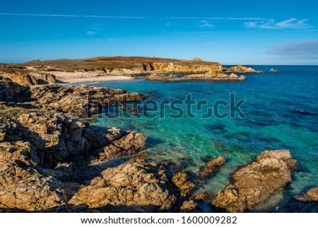 The view of rocky coastline and sandy beach in northwestern part of Hoedic island, the Cape  of Vieux Chateaux is at background. Brittany, France.