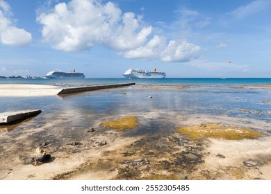 The view of rocky Grand Cayman island beach shore and drifting cruise ships in a background (Cayman Islands). - Powered by Shutterstock