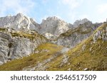 View of rocky mountain peaks and yellow grassy slopes below. Landscape from the high mountain valley Lugo i kuq (or Ljubokuć), located in Prokletije National Park. Hiking in the East Montenegro