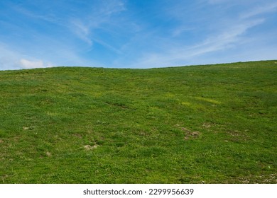 View of rolling green hills and blue sky in the spring season, Italy
