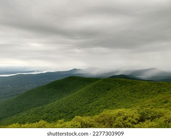 View of rolling green mountain range, with an overcast sky. Taken in the Catskills, a mountain range that is part of the northernmost reaches of the Appalachia.