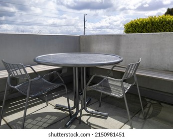 View Of A Rooftop Balcony With A Round, Metal Table And Two Chairs, Overlooking Downtown Bellevue, WA