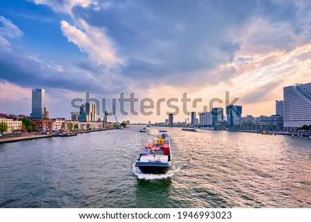 View of Rotterdam cityscape and Erasmus bridge over Nieuwe Maas with cargo ships and boats. Rotterdam, Netherlands