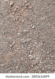 view of rough, unpaved ground composed of a mixture of dirt, gravel, and small rocks.