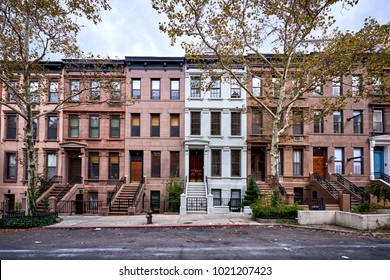 a view of a row of historic brownstones in an iconic neighborhood of Manhattan, New York City - Shutterstock ID 1021207423