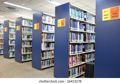 A view of rows of bookshelves and a study area inside a library