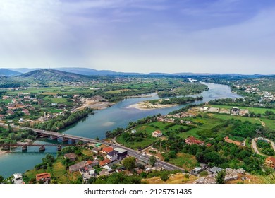 View From The Rozafa Castle To The Albanian Rural Landscape Of The Drin River Valley. Beautiful Summer Panorama With A Settlements On The Plain Riverbank Among The Mountains