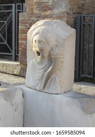 View Of The Ruins Of A Water Fountain With A Face Sculpture Located In Pompeii, Italy