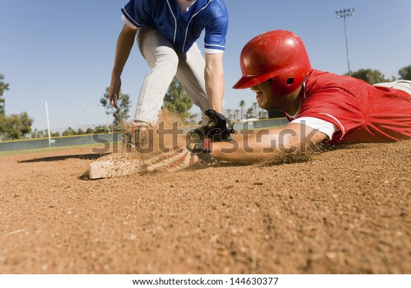 View of a\
runner and an infielder reaching the\
base