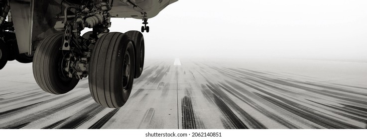 A view of a runway at one of the UK's largest growing airports. A passenger airline or cargo aircraft landing or taking off before the airport is engulfed by fog.