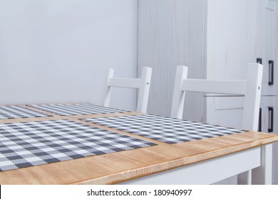 View Of A Rustic Kitchen Table With White Chairs