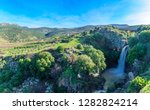 View of the Saar Waterfall, with Mount Hermon and Nimrod Fortress in the background, in the Golan Heights, Morthern Israel