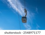 View of the Saentis aerial cableway cabin against blue sky and white cloud from below at Schwaegalp, Canton of Appenzell Ausserrhoden, Switzerland