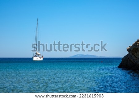 View of a sailboat at the famous  Mylopotas beach in Ios Greece
