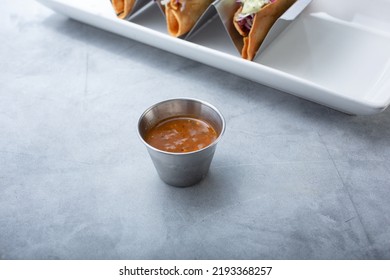 A View Of Salsa In A Metal Condiment Cup.