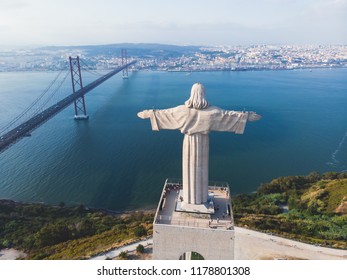 View of The Sanctuary of Christ the King, Cristo Rei, Almada, Lisbon, with 25 de Abril Bridge suspension Bridge, Tagus river, aerial drone view in summer sunny day