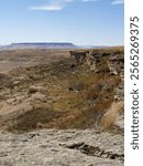 View of the sandstone cliffs of the First Peoples Buffalo Jump in Montana with Square Butte mountain in the distance.