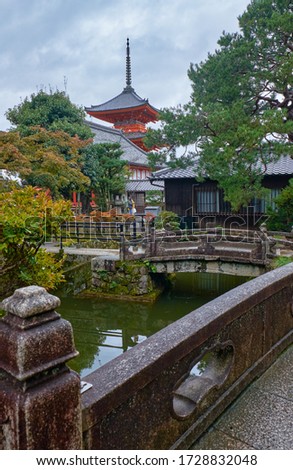 The view of Sanju-no-to three-storied pagoda over the watercourse with old stone bridges at Kiyomizu-dera temple complex. Kyoto. Japan