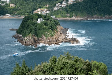 View of Santa Clara from Monte Urgull in Donostia - San Sebastian. There is an abandoned lighhouse in the island, together with a small pier. Ferry boats are wandering around , carrying tourists. - Powered by Shutterstock