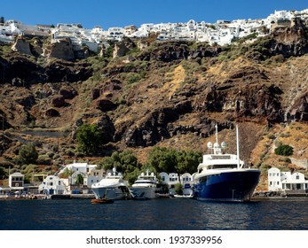 View Of Santorini Island  Capped With White Buildings From The Blue Water Below