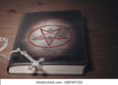 View Of Satan Bible With Crucifix On Wood Background. Dark Tone.