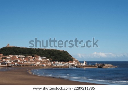 view of scarborough south bay beach with the town lighthouse harbour and on a sunlit summer day