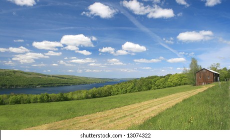 VIew Of A Scenic, Green Pasture Or Agricultural Field, With House And A View Of Keuka Lake, One Of Eleven Fingerlakes In Upstate New York