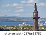 The view from the Scott Monument to the statue of Scottish statesman Henry Dundas on the top of Melville Monument on the background of Edinburg, Firth of Forth and Fife. Edinburgh, Scotland