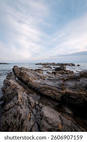View of the sea cliffs at springtime sunset in Nervi, one of the east neighborhoods of the city of Genoa (Ligurian Region, Northern Italy). The city is famous for its commercial and touristic port.