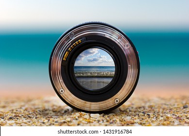 View of the sea surf through a photographic lens lying on a sandy beach on a sunny day.
