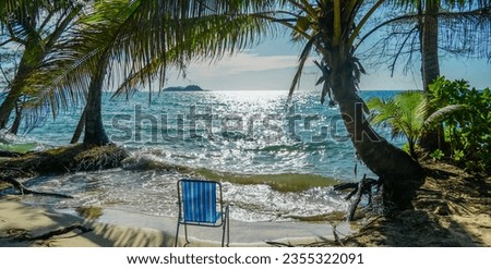 View seaside of coconut tree with beach chair and blue-green sea with blue sky background, Chang island, Thailand.