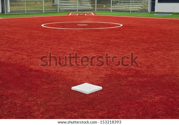 A view from second base looking to home plate over\
the pitcherÃ¢Â?Â?s mound with artificial turf at a school softball\
field. The colors of the artificial turf are a high contrast to a\
normal playing field.