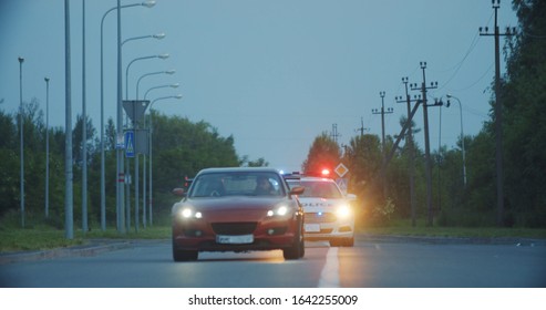 View Of Self-willed Young Man Driving On Modern Sports Car From The Police. Police Officer Cop Chasing A Thief Driving A Patrol Car On The Highway At Daytime. Police In Pursuit.