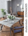 a view of a set dining table in a chic expensive bright interior of a huge living room in a historic mansion with arched arches, columns and white walls decorated with ornaments and stucco.