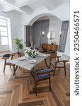 a view of a set dining table in a chic expensive bright interior of a huge living room in a historic mansion with arched arches, columns and white walls decorated with ornaments and stucco.