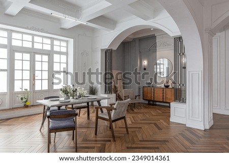 a view of a set dining table in a chic expensive bright interior of a huge living room in a historic mansion with arched arches, columns and white walls decorated with ornaments and stucco.