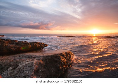 View of the setting sun on the Black Sea from the pier at Cape Kadosh. Stone beach, pink sky, a lot of cloud - Powered by Shutterstock