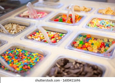 A view of several containers of assorted toppings, seen at a local frozen yogurt shop.