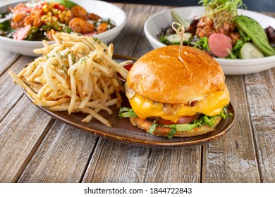 A view of several gastropub entree fare, featuring a cheeseburger and french fries plate. - Shutterstock ID 1844722843