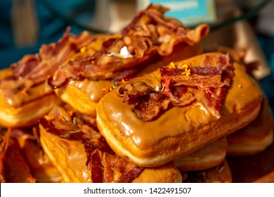 A View Of Several Maple Bar Donuts With Bacon Toppings.