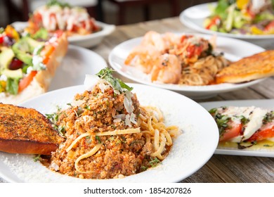 A View Of Several Mediterranean Entrees On A Table Surface.