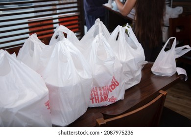 A View Of Several Thank You Plastic Bag To Go Orders, On Display At A Front Table Of A Local Restaurant.