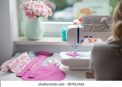 view of sewing room with sewing machine, fabric,, flowers and woman