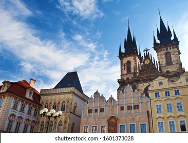 View of the sharp towers of the Church of Mother of God before Týn and nearby houses against vibrant blue sky and white couds. Prague, Chezh Republic