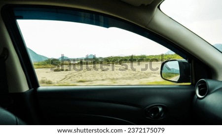 View in the side window of a car while driving at rural country side road. Sideview vehicle mirror look of the passenger. Travel and trip.
