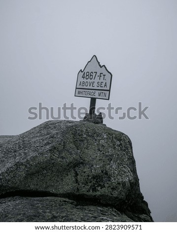 View of a sign marking the elevation at Whiteface Mountain. A sign shows the height of 4867 feet above sea level at Whiteface Mountain in cloudy weather.