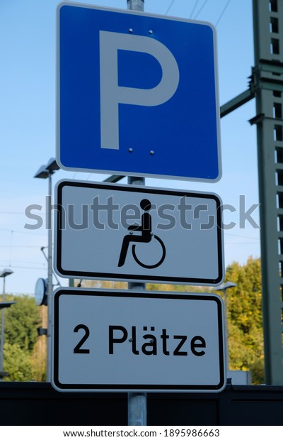 view of a sign with a sign for parking and\
underneath a wheelchair