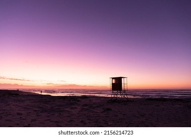 View of silhouette lifeguard hut on sandy beach against sea and clear purple sky, copy space. unaltered, nature and protection concept. - Powered by Shutterstock